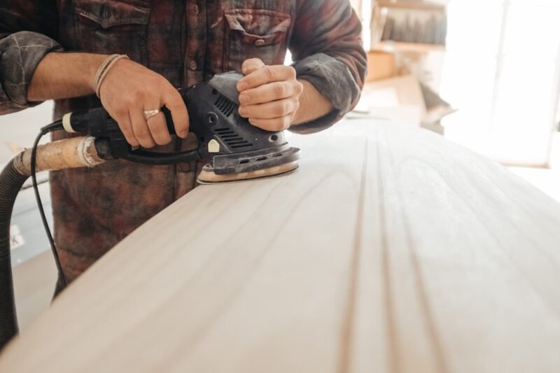 acamento — craftsman sanding a wood surface during the finishing stage